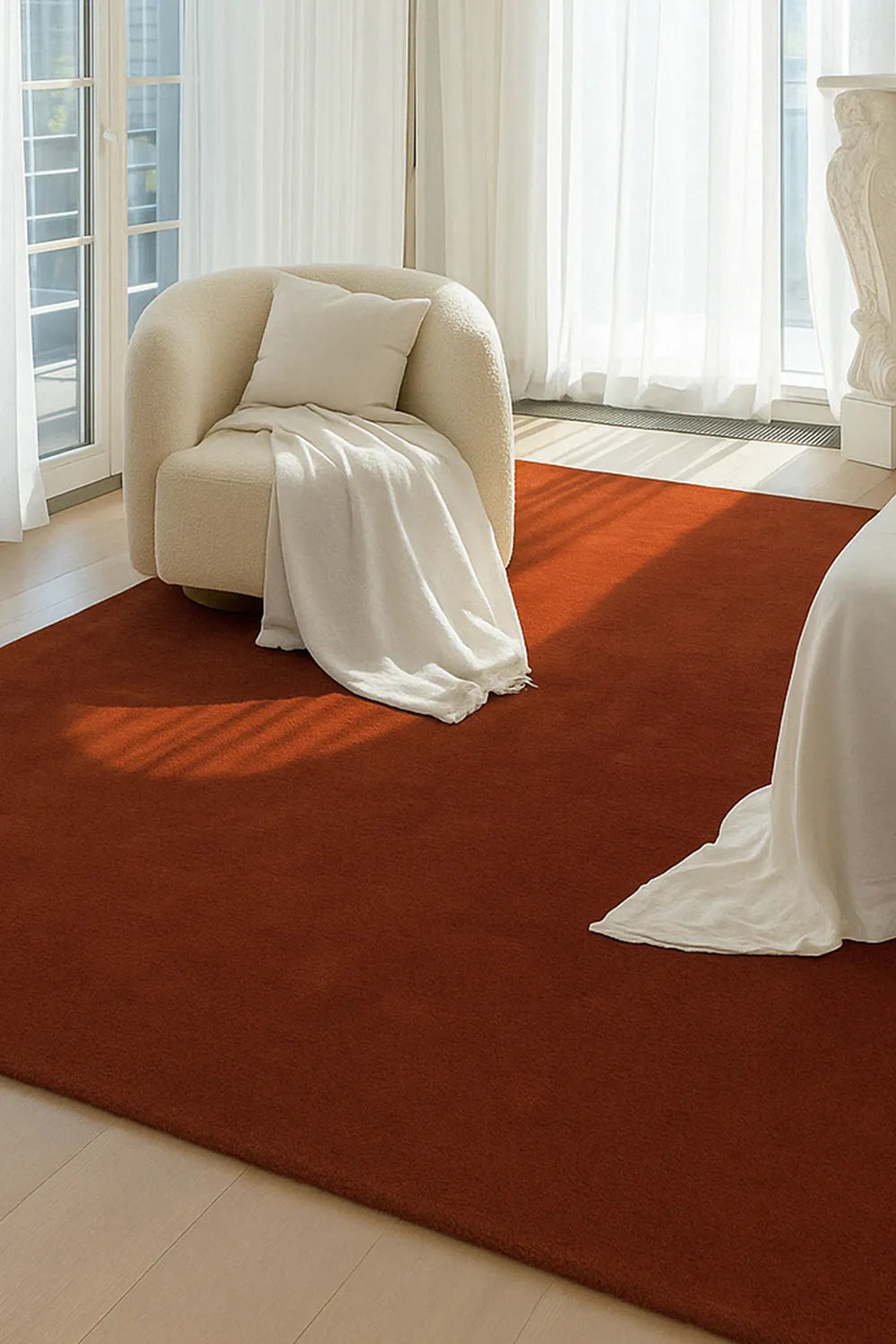 Rich terracotta orange wool rug styled under modern seating, ideal 9x12 rug for dining rooms or Japandi-inspired living areas