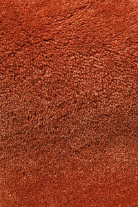 Close-up of a textured burnt orange wool rug