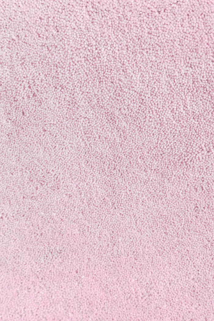Close-up of thick blush light pink wool rug with plush hand-tufted pile, perfect for high-pile bedroom rugs or luxury nurseries