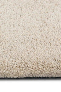 close up of hand tufted thick wool rug pile in off white oreo