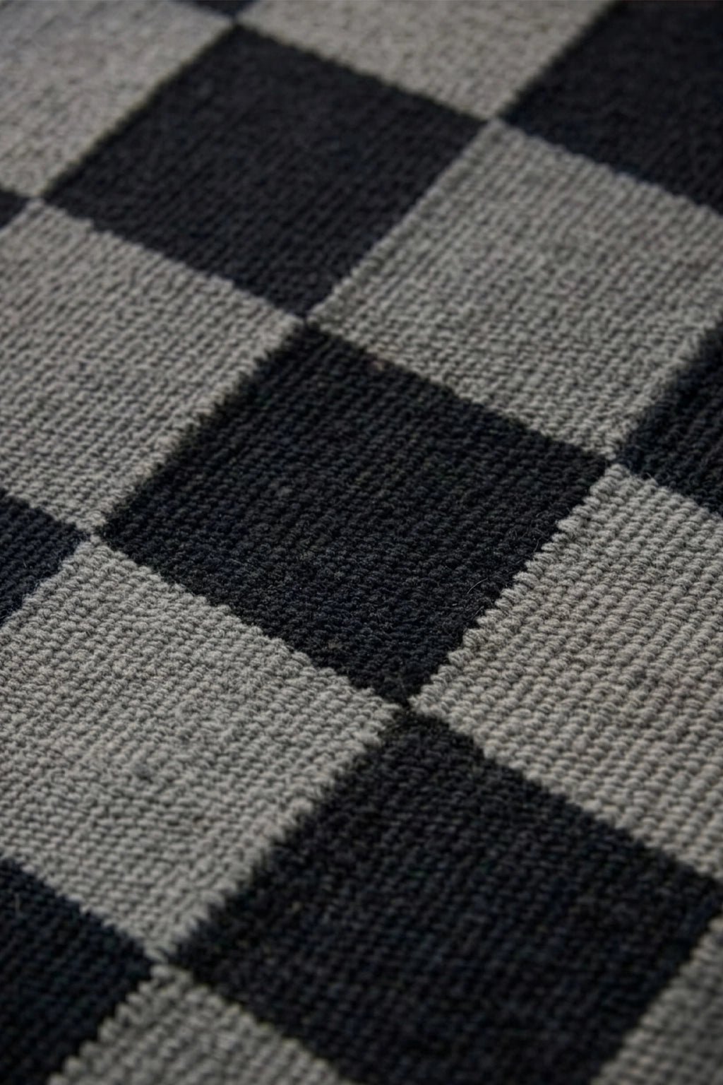 Close-up of a checkered pattern rug with black and gray squares