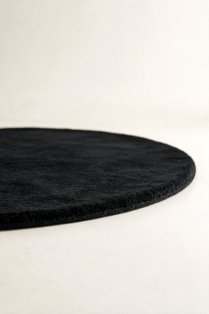 Round black rug on a white background