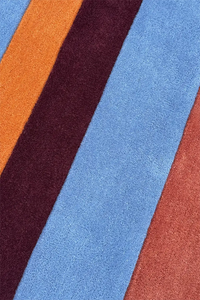 Close-up of a textured wool rug with multicolored stripes mid century inspired