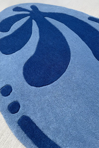 Irregular sculpted floral rug in lagoon blue, modern wool design for bedroom, nursery, or statement space