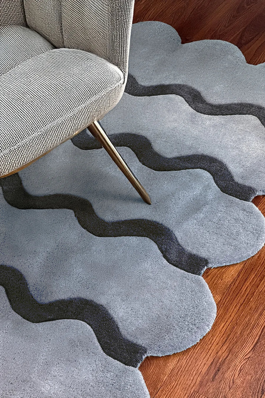 Scalloped light blue wool ripple rug styled with chair, boutique custom rug
