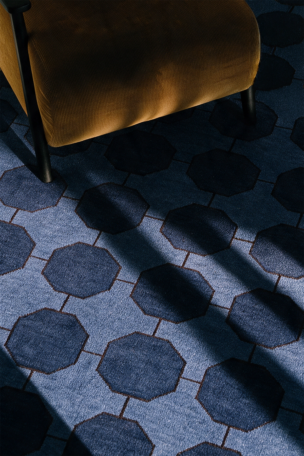 a blue geometric rug in a sunny living room lifestyle