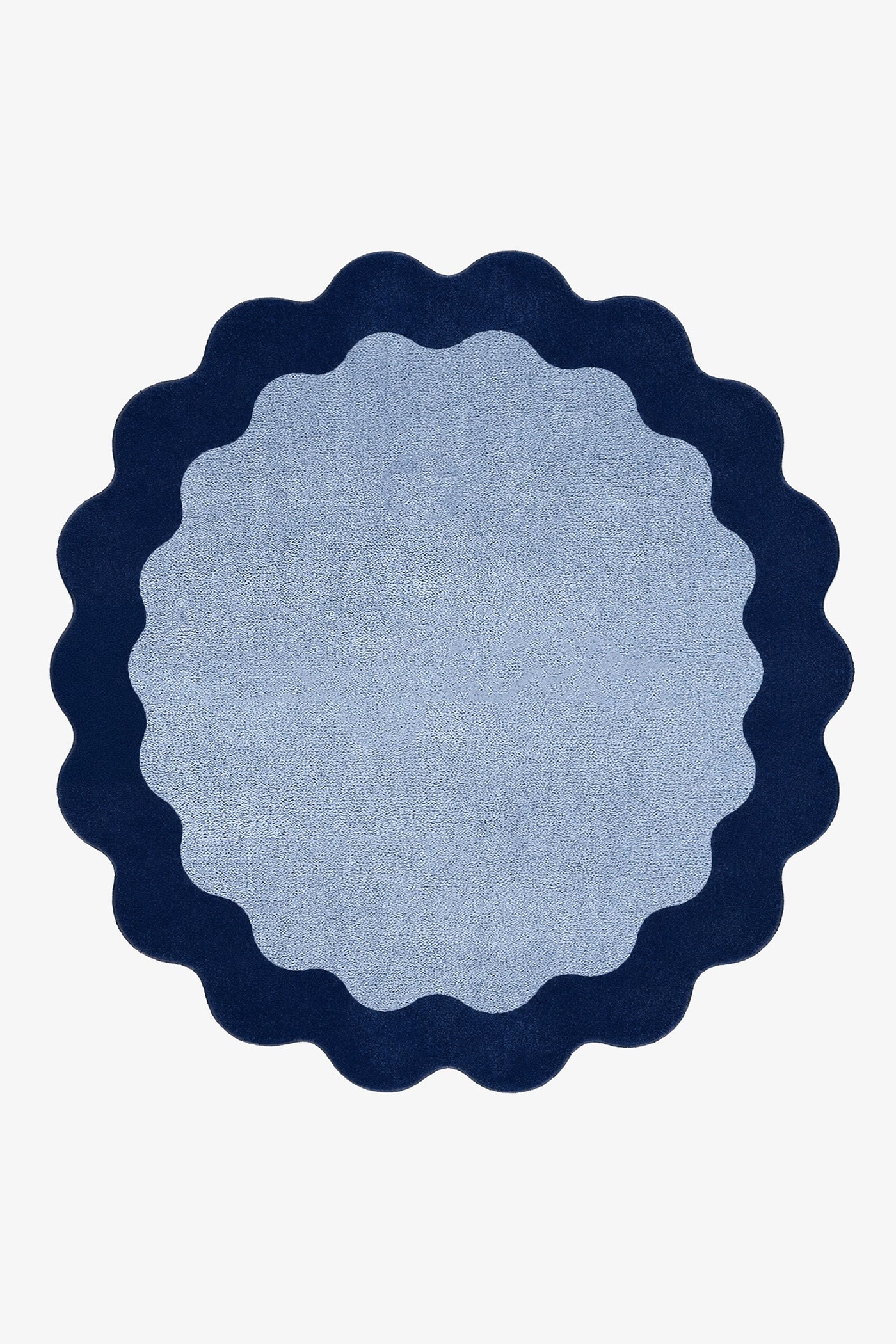 A round rug with a scalloped edge, featuring a light blue center and a dark navy blue border, shown flat against a white background.