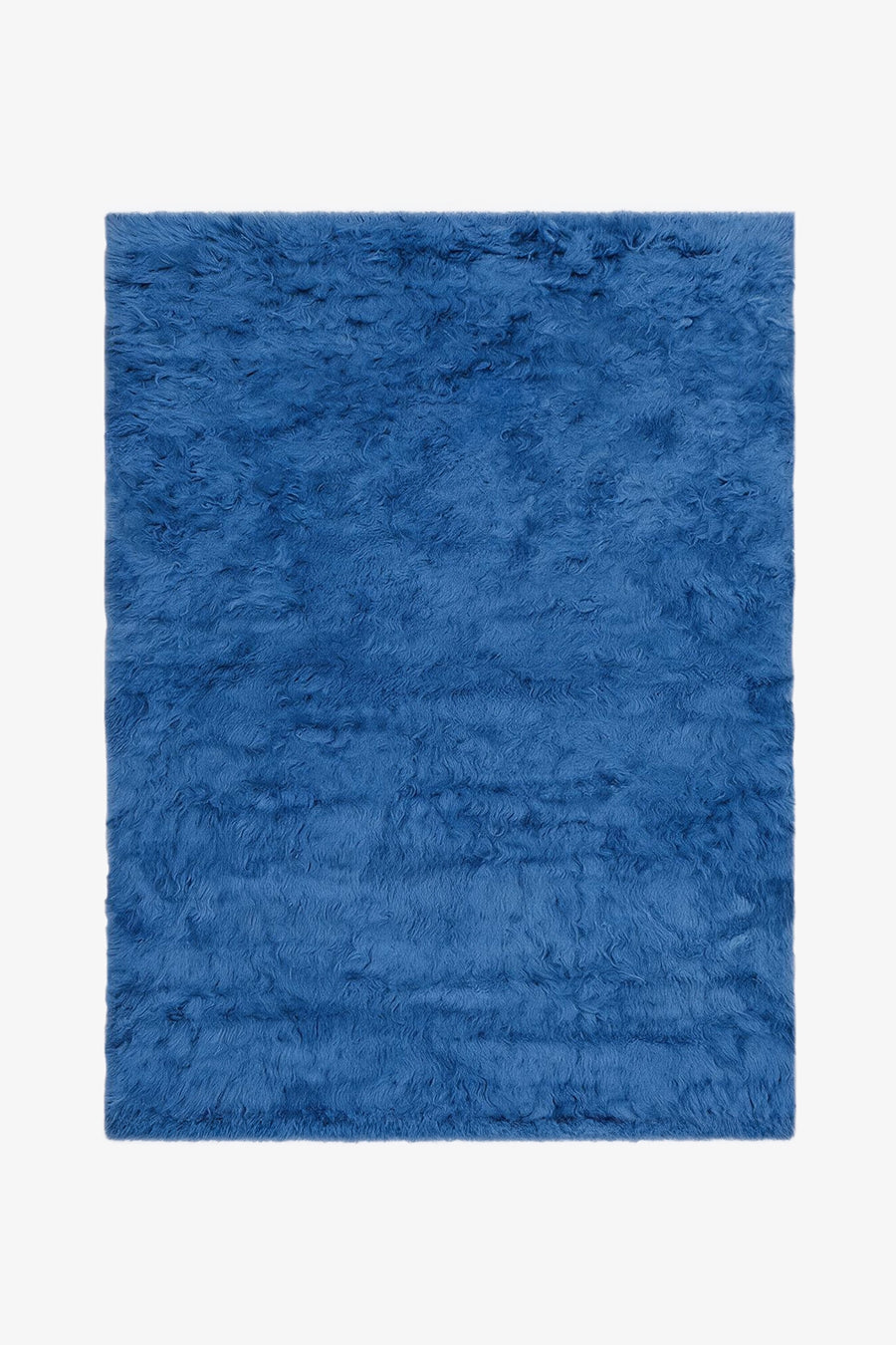 A blue shag rug with a thick, fluffy texture, shown flat against a plain white background.
