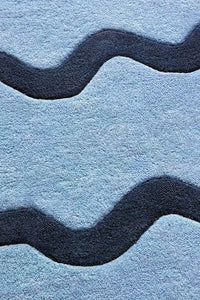Close-up of navy and light blue wavy stripe wool rug, bold modern graphic runner rug