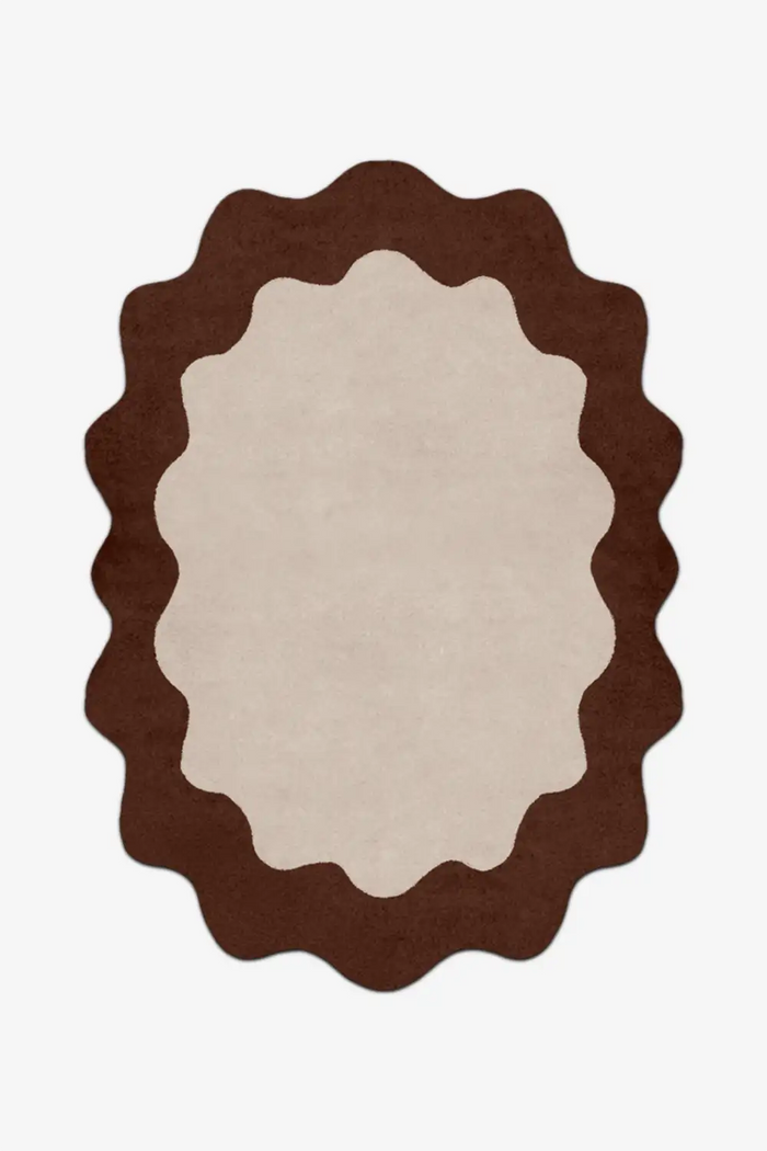 Round rug with scalloped edge in brown and beige on a white background