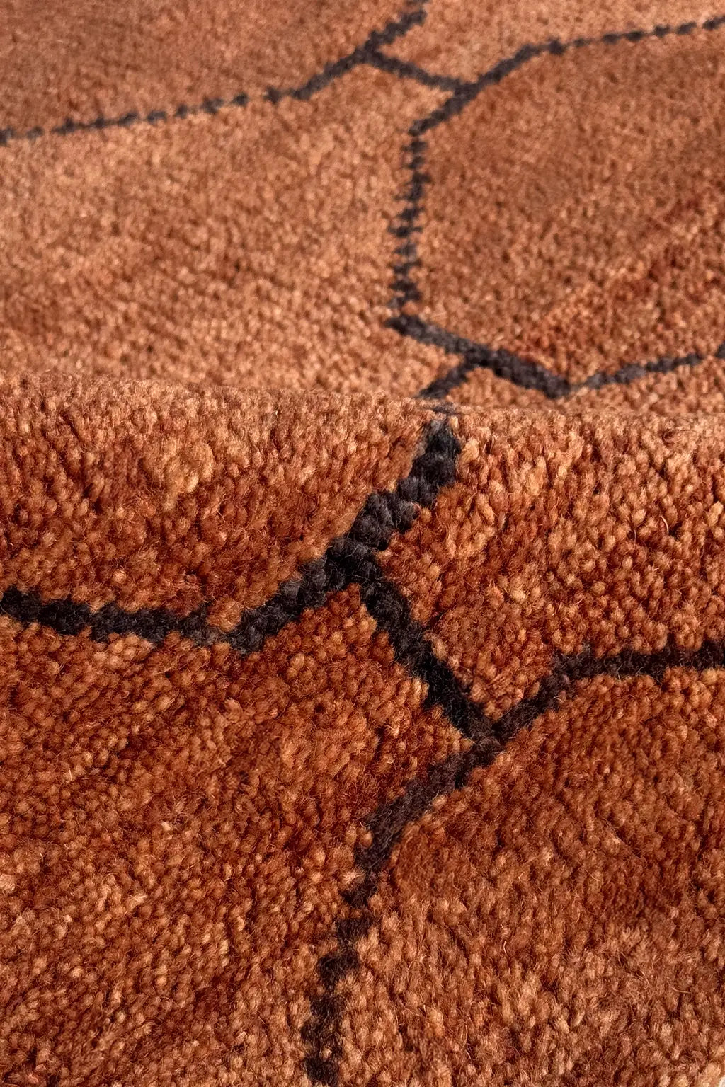 Close-up of a brown wool runner rug surface with black lines