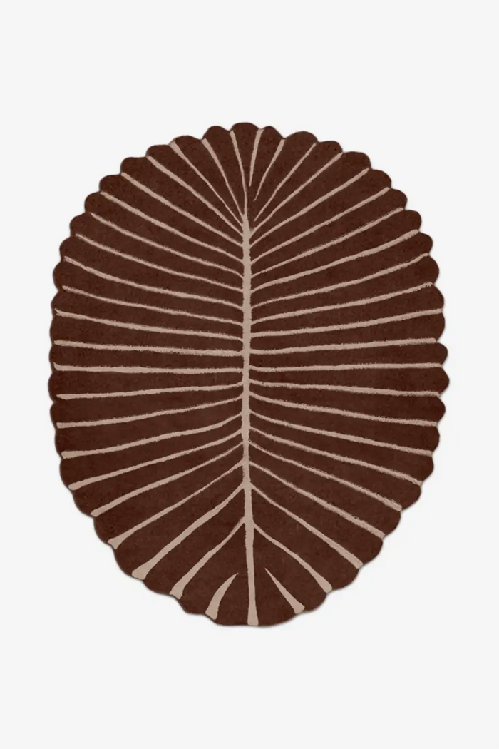 Brown oval rug with a leaf pattern on a white background