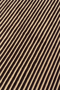 Brown and tan striped wool rug with a tight modern weave and warm neutral tone