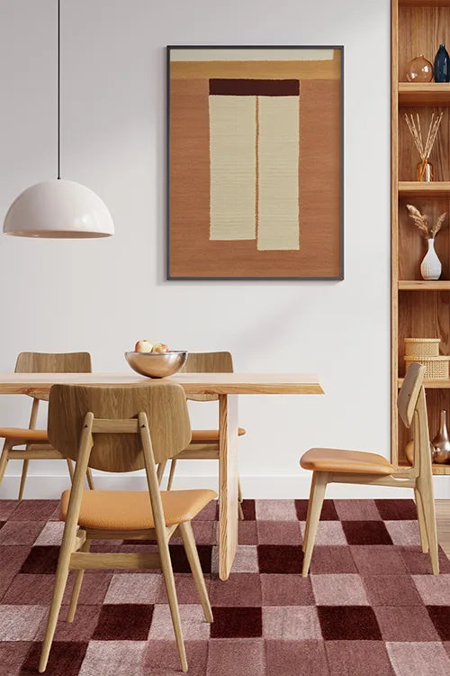 Dining room with wooden table and chairs, burgundy checkered wool rug, and framed artwork on the wall.