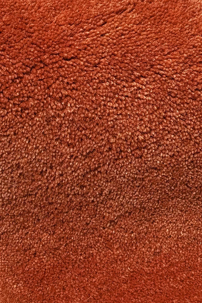 Close-up of rust burnt orange rug texture hand tufted