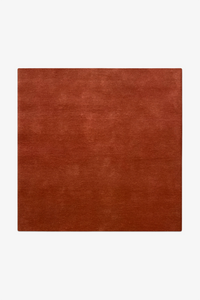 square burnt orange rug on a white background
