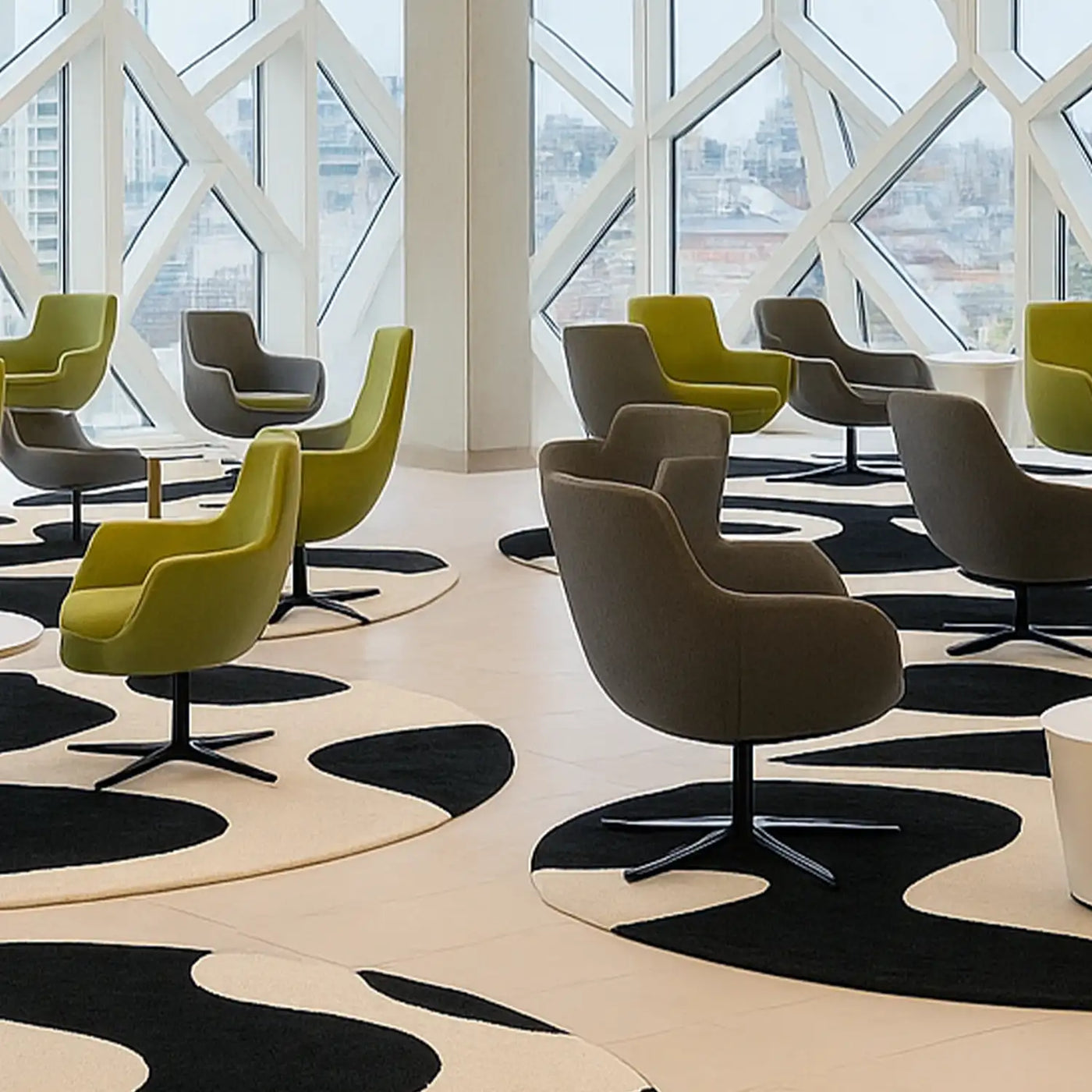 black and white round abstract rugs placed under green chairs in the lobby of an architecture firm