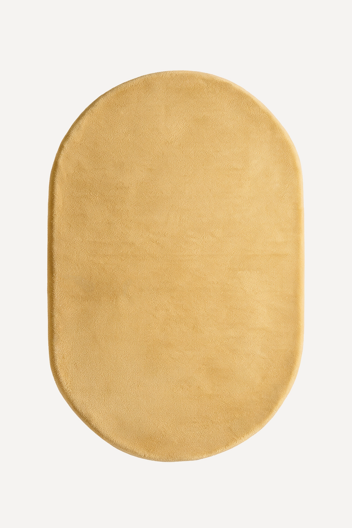 a light yellow oval rug shown on a white backgorund