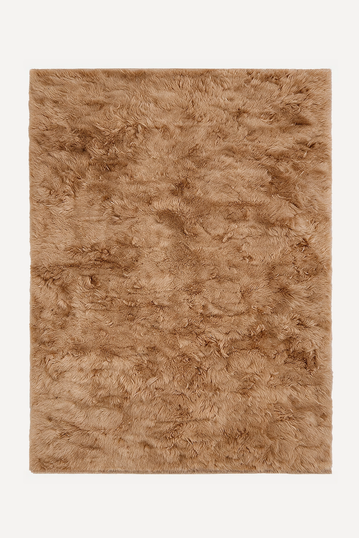 A rectangular shag rug in a warm tan-brown color, shown flat against a light off-white background camel