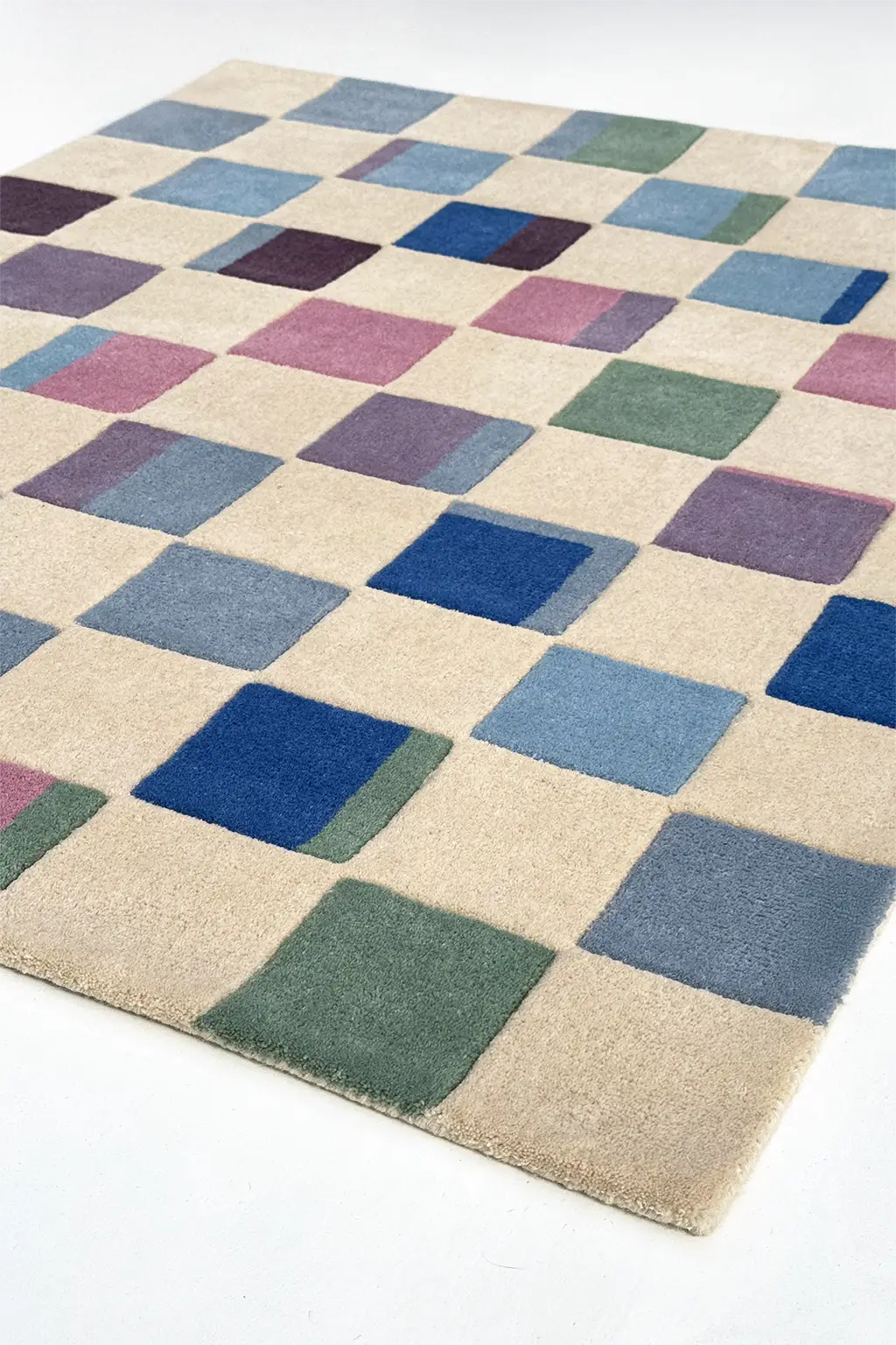 Checkered rug with blue, green, and purple squares on a beige background