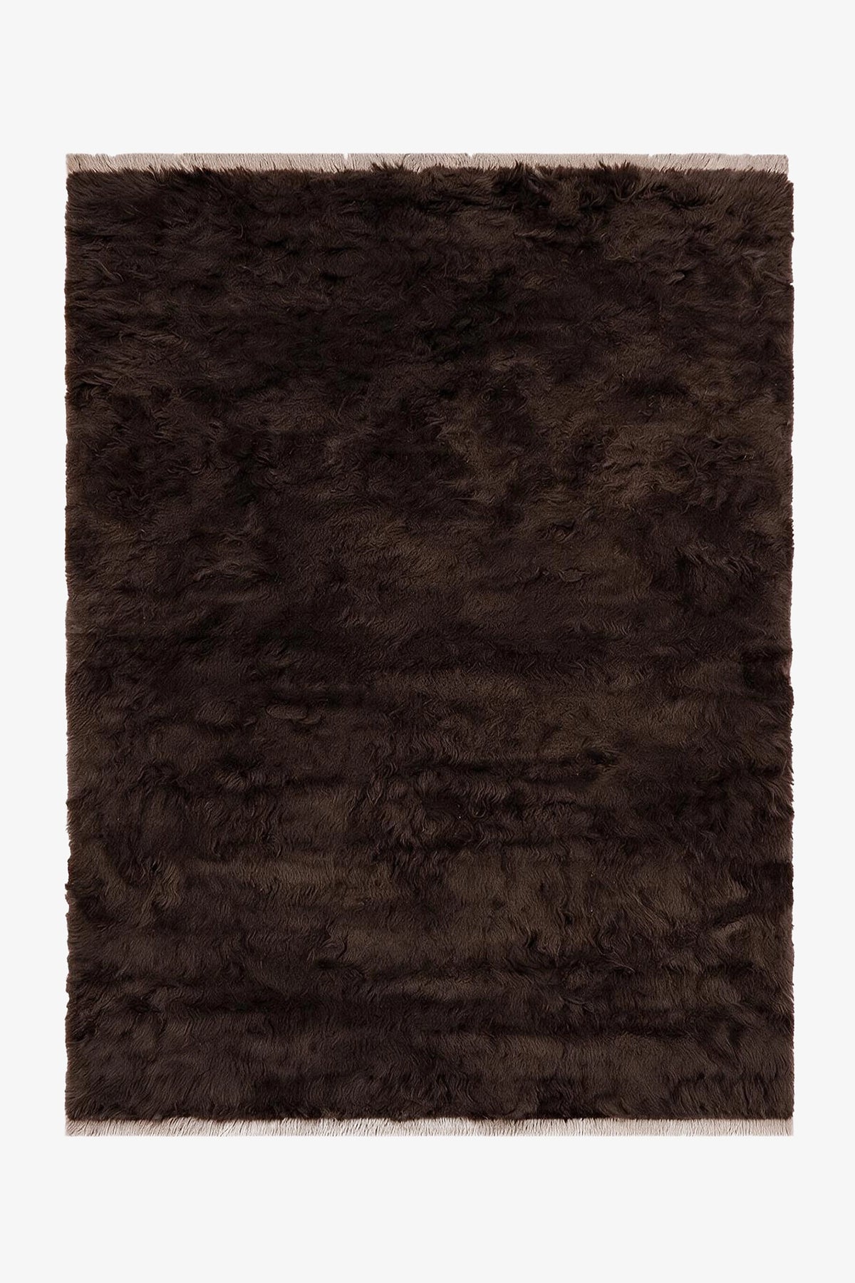 A dark brown shaggy area rug with a textured, fluffy pile and fringed edges, shown flat against a plain white background.