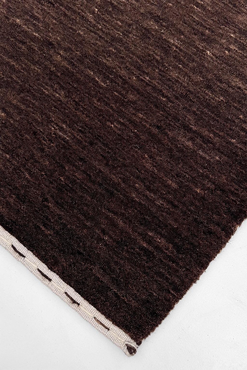 close-up texture of dark brown hand-loomed area rug 