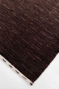 close-up texture of dark brown hand-loomed area rug 