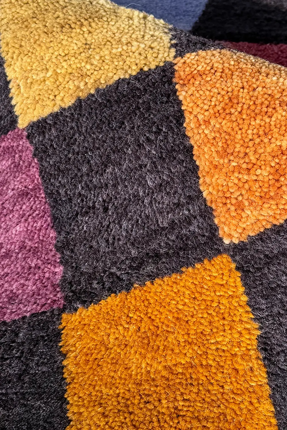 soft texture detail of modern round checkered wool rug in multicolor pattern