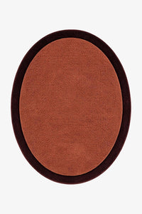 An oval-shaped brown rug with a dark brown border, shown from a top-down view on a light gray background.