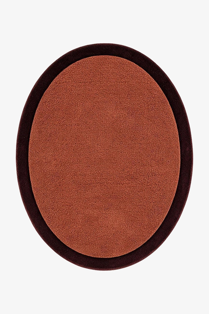 An oval-shaped brown rug with a dark brown border, shown from a top-down view on a light gray background.