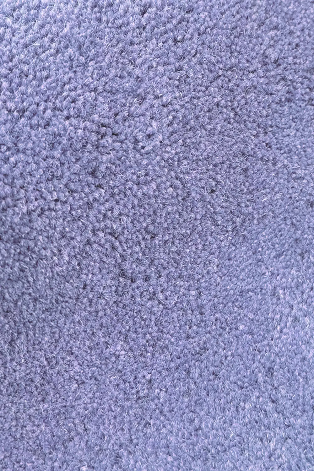 Textured wool close-up of purple scalloped rug with rich plush pile for cozy spaces