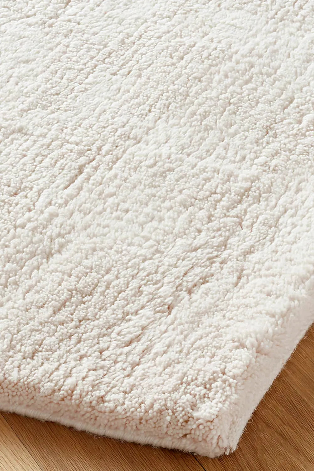 Close-up of plush thick cream wool rug showing deep pile texture, ideal for luxury nursery rugs or cozy living rooms