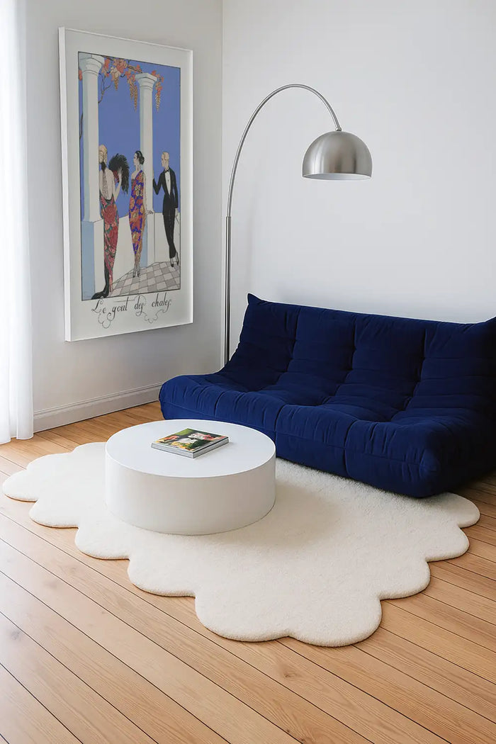 Off white cream sculptural wool rug with scalloped edges styled in a modern living room with wood floors and low sofa lifestyle