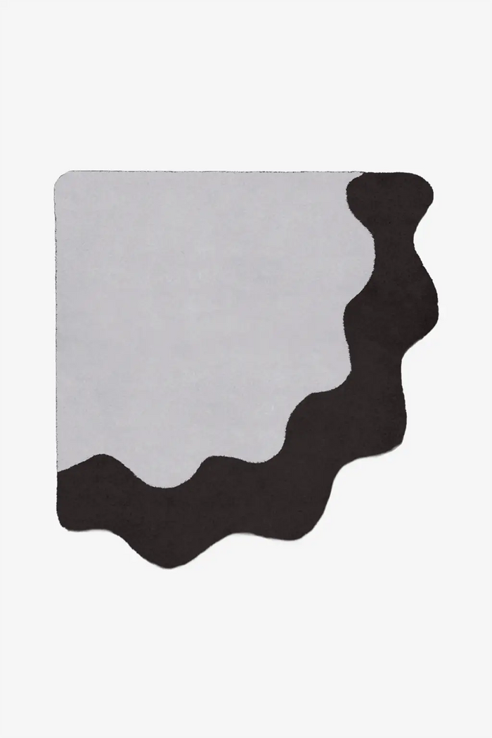 Black and gray wavy quarter circle rug on a white background