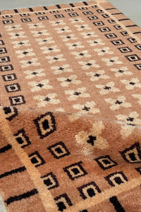 Tan and brown wool rug with intricate knotted texture and desert-inspired box matrix pattern, modern geometric area rug