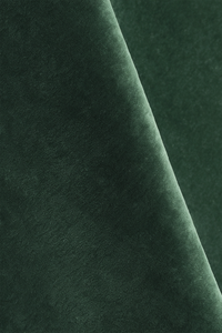 Dark forest green wool rug with a soft, plush texture, shown draped diagonally across the frame.