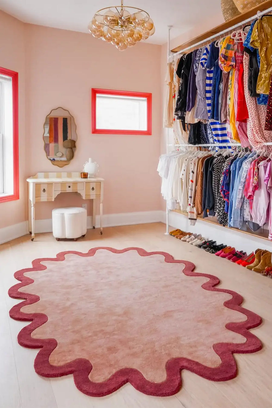 Soft wool scalloped rug in dusty pink with burgundy border styled in colorful modern bedroom