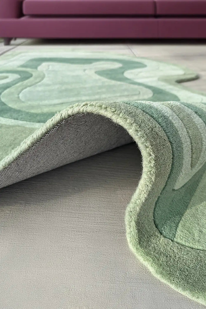 Soft sage green wool rug with sculptural waves, perfect for colorful modern living rooms