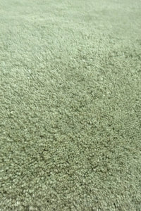 Soft sage green wool square rug surface shown close up, emphasizing plush hand-tufted quality for fun and functional playroom rugs