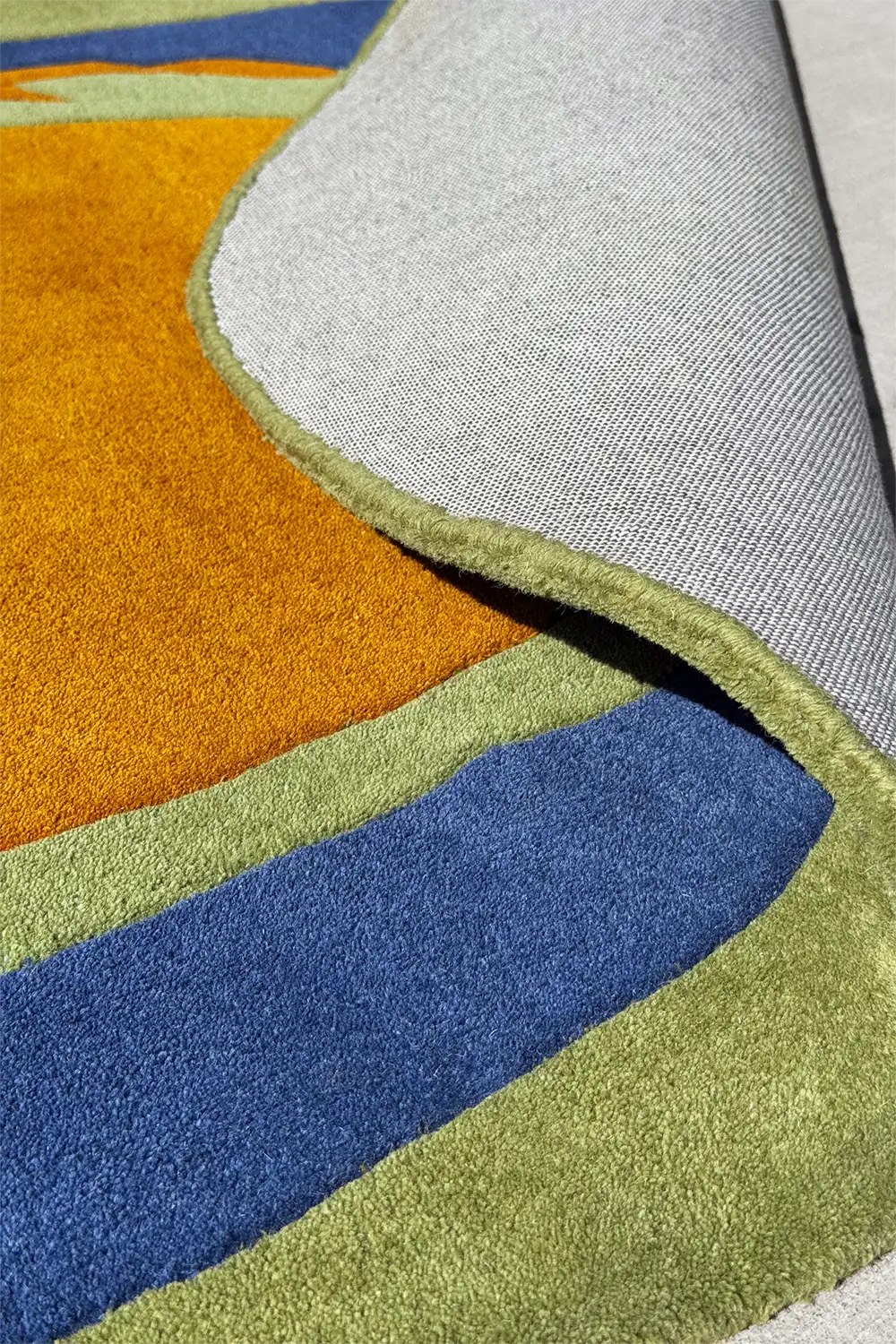 Hand-tufted oval area rug in green and navy with soft orange, perfect as a funky wool rug in unique sizes