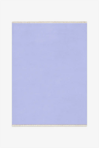 Light blue rug with white fringe on a white background