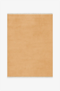 gold beige knotted rug with white fringe on a white background