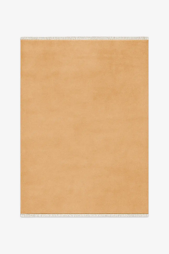 gold beige knotted rug with white fringe on a white background
