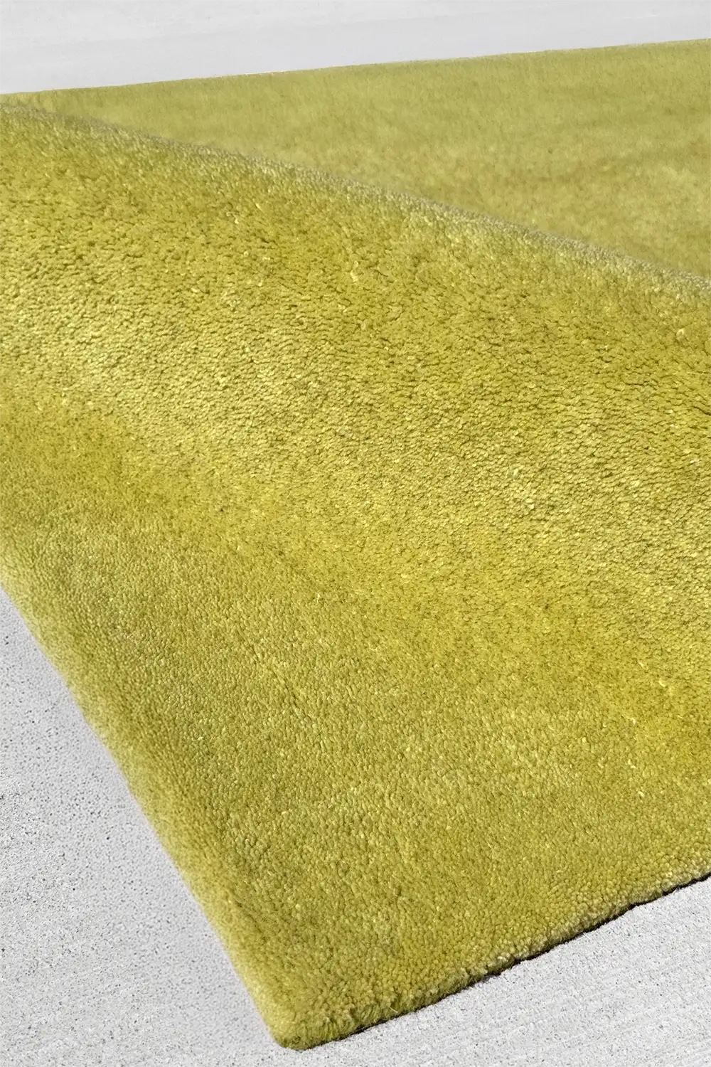 lime green tufted wool rug on a light gray background