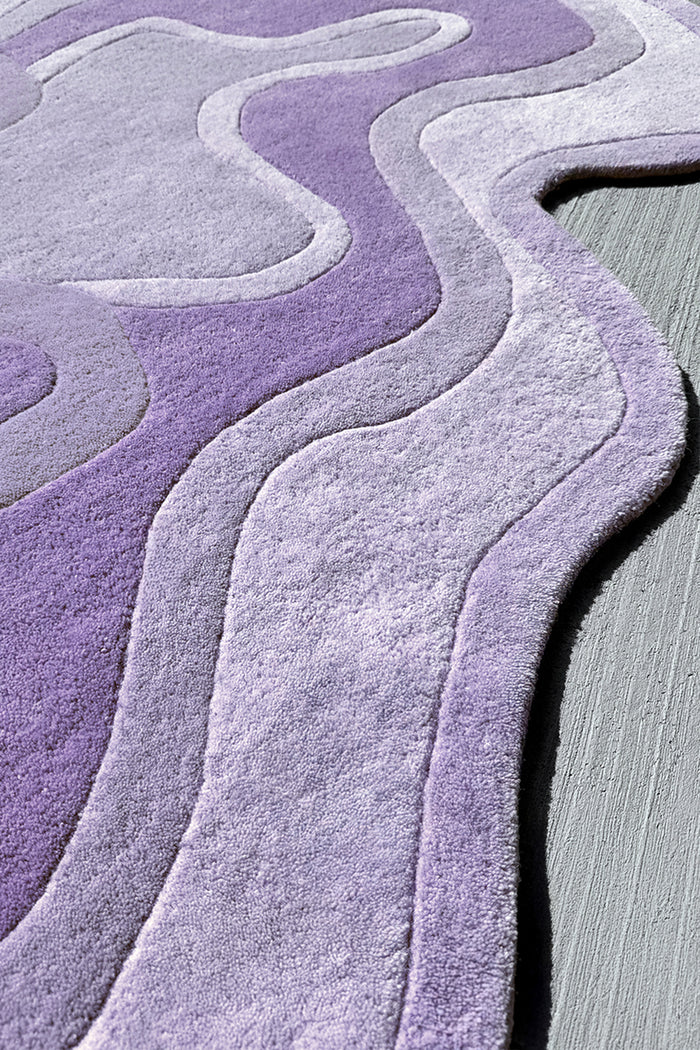 Lavender wool rug in wavy organic shape with high low pile, soft modern design
