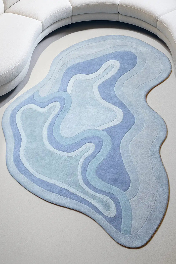 Sculpted blue wool rug in a modern living room with light wood floors and organic curves lifestyle