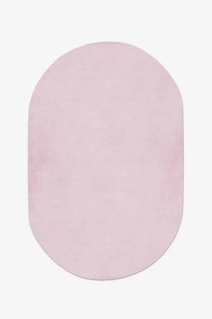 soft light pink oval rug on a white background