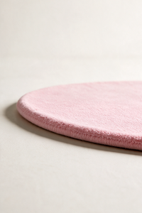light pink oval rug shown from a low angle highlighting its plush pile