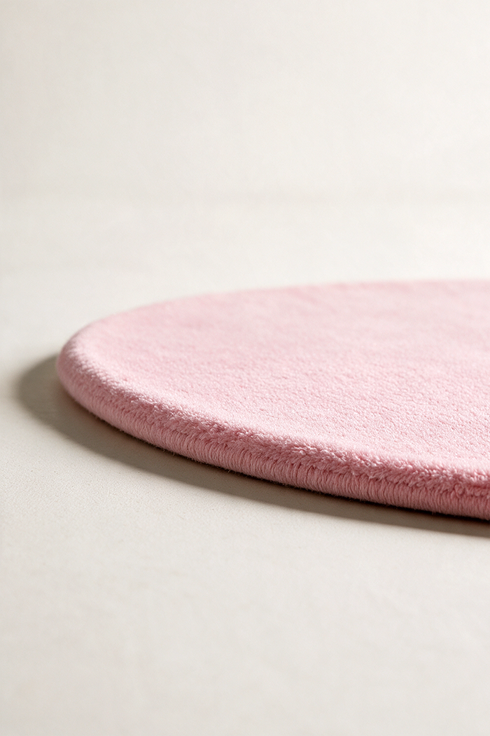 light pink oval rug shown from a low angle highlighting its plush pile