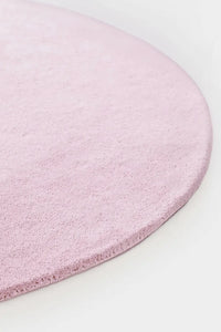 Close-up of soft tufted light pink wool round rug, perfect for kids rooms and nurseries